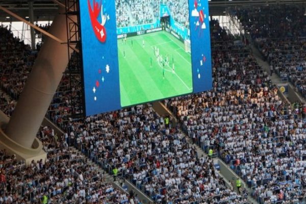 Large stadium video screen showing a live sports event